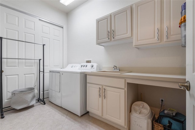 washroom with washing machine and dryer, cabinet space, a sink, and light tile patterned flooring