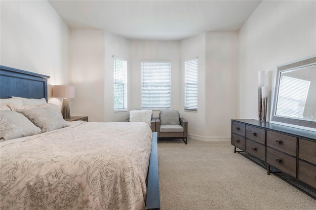 bedroom with light carpet and baseboards