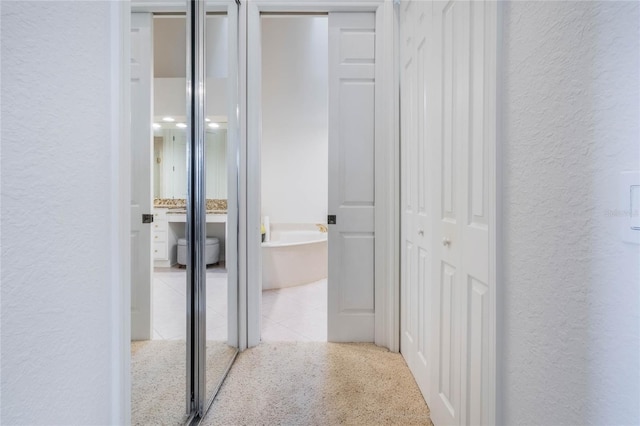 corridor with tile patterned flooring and a textured wall