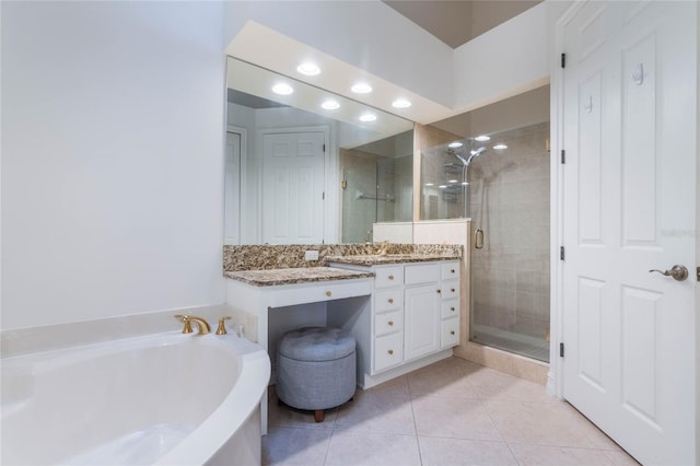 full bathroom with a garden tub, a shower stall, tile patterned floors, and vanity