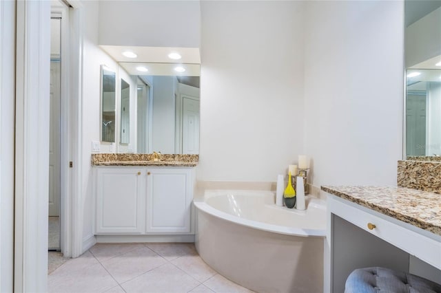 full bathroom with tile patterned flooring, a bath, and vanity