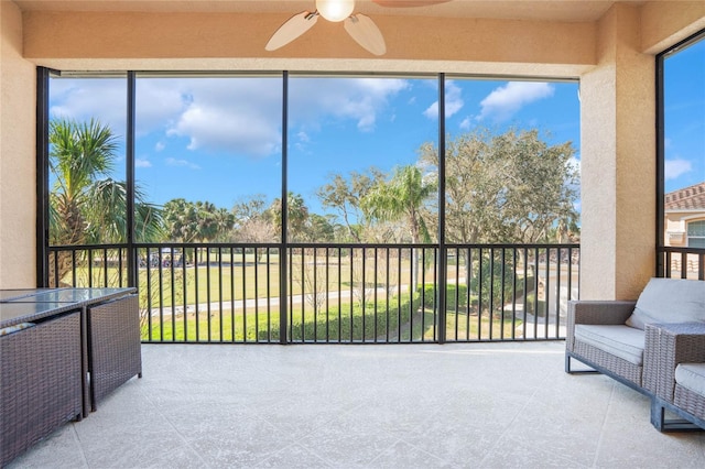 sunroom / solarium featuring a ceiling fan