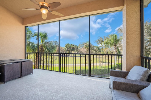 sunroom / solarium featuring a ceiling fan