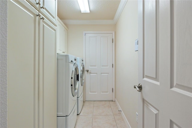 laundry area with a textured ceiling, cabinet space, separate washer and dryer, crown molding, and light tile patterned floors