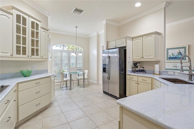 kitchen with visible vents, a sink, stainless steel refrigerator with ice dispenser, crown molding, and a chandelier