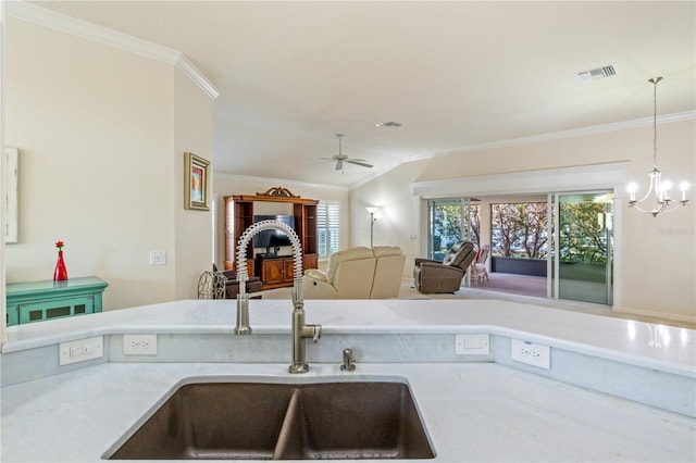 kitchen featuring visible vents, ornamental molding, a sink, vaulted ceiling, and open floor plan