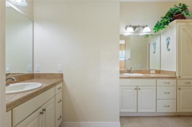 bathroom with tile patterned flooring, two vanities, and a sink