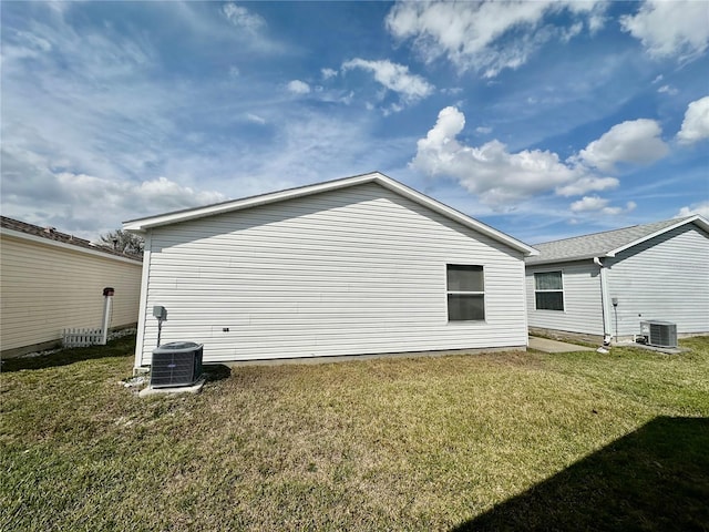 view of side of home featuring a yard and central air condition unit