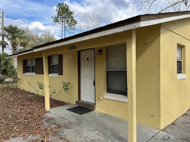 view of exterior entry with stucco siding