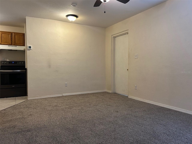 spare room featuring light carpet, ceiling fan, and baseboards