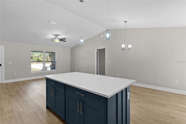 kitchen with light wood-style flooring, ceiling fan with notable chandelier, open floor plan, light countertops, and a center island