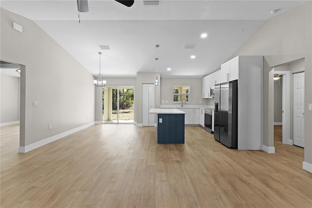 kitchen featuring ceiling fan with notable chandelier, stainless steel appliances, a sink, light countertops, and a center island