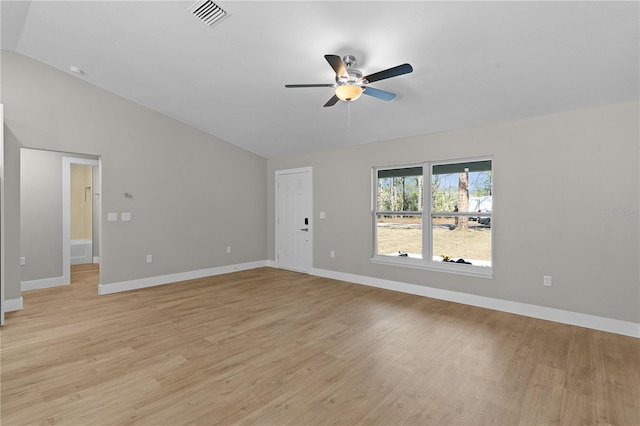 spare room featuring light wood finished floors, lofted ceiling, visible vents, ceiling fan, and baseboards