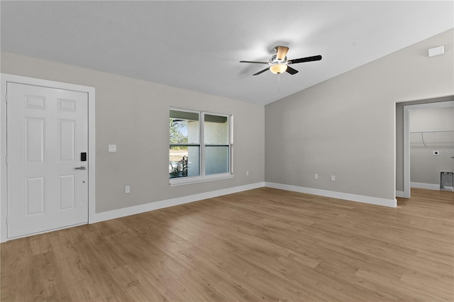 interior space featuring lofted ceiling, ceiling fan, baseboards, and light wood-style flooring