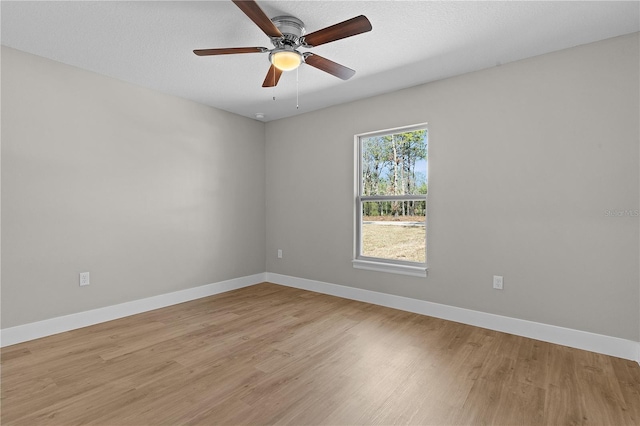 unfurnished room with baseboards, ceiling fan, and light wood-style floors