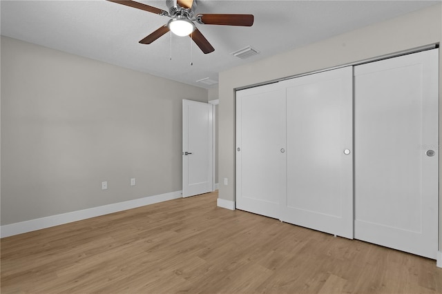 unfurnished bedroom with light wood finished floors, a closet, visible vents, a ceiling fan, and baseboards