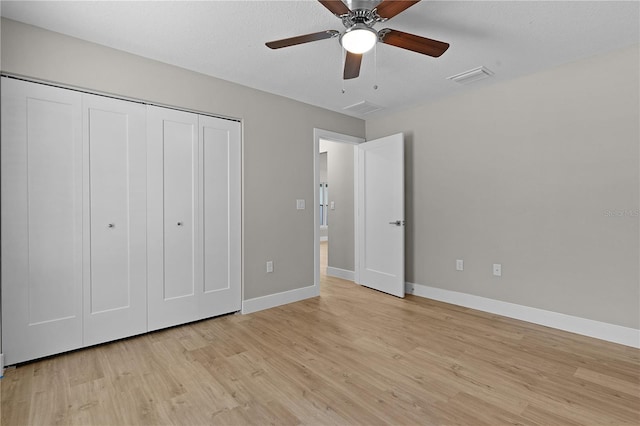 unfurnished bedroom featuring a closet, visible vents, ceiling fan, light wood-type flooring, and baseboards