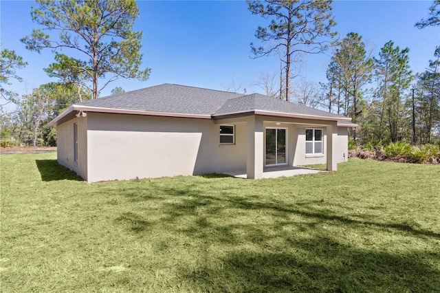 back of property with a yard, a patio, and stucco siding