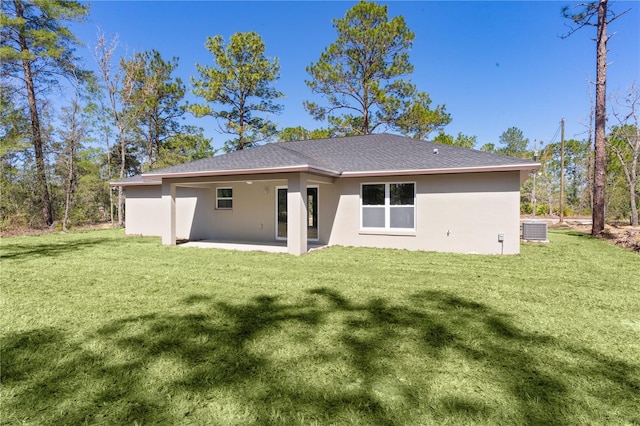 back of property with a yard, a patio, central AC unit, and stucco siding