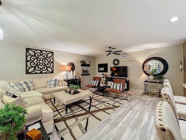 living room with a textured ceiling, light wood-type flooring, ceiling fan, baseboards, and recessed lighting