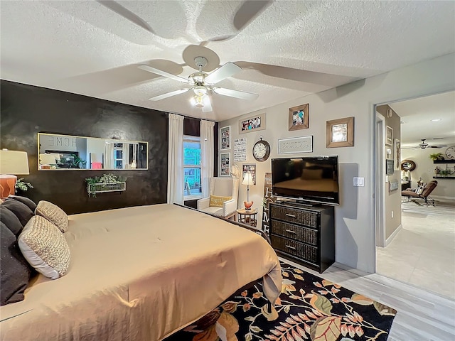 bedroom with a ceiling fan and a textured ceiling