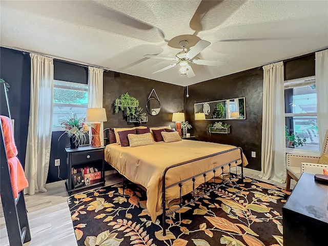 bedroom featuring baseboards, a ceiling fan, and a textured ceiling