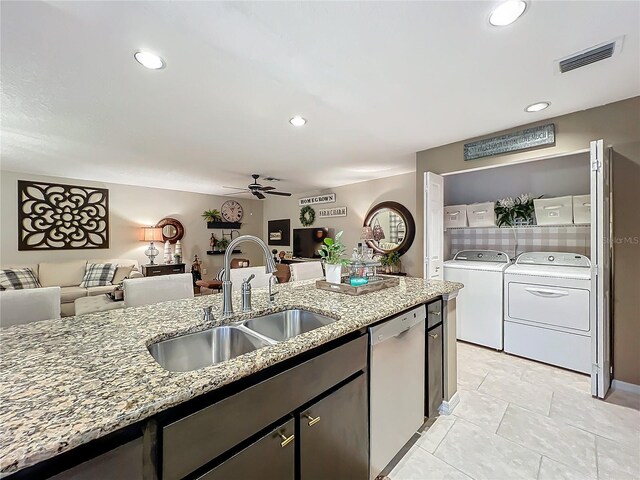 kitchen with visible vents, stainless steel dishwasher, a sink, washing machine and clothes dryer, and open floor plan