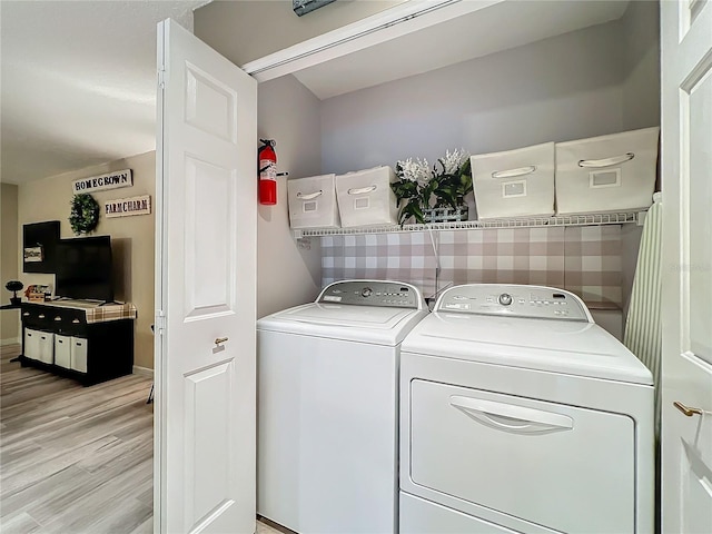washroom with light wood-style floors, washer and dryer, and laundry area