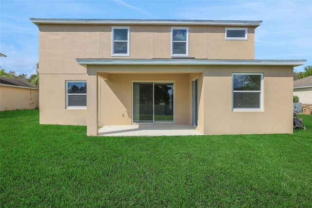 back of property with a patio, a yard, and stucco siding