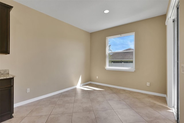 unfurnished room featuring baseboards and light tile patterned floors