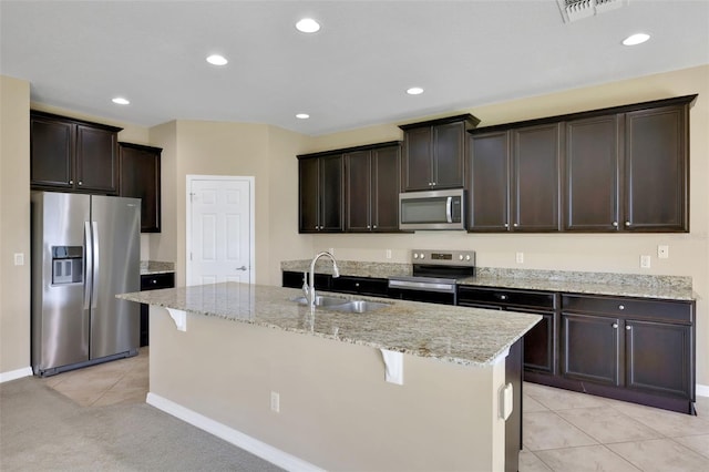 kitchen with light tile patterned floors, stainless steel appliances, visible vents, a sink, and dark brown cabinets