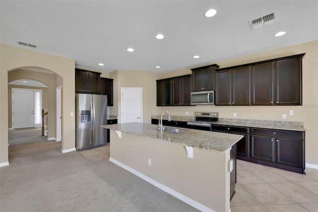 kitchen with arched walkways, visible vents, stainless steel appliances, and a sink