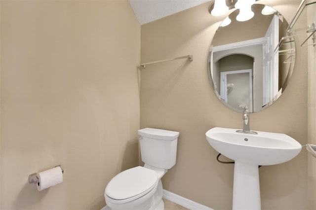 half bathroom with toilet and baseboards