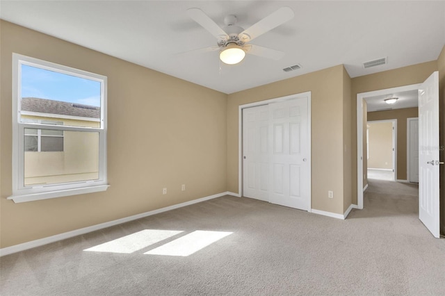 unfurnished bedroom with carpet floors, baseboards, visible vents, and a closet