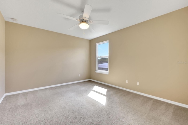 empty room with carpet floors, ceiling fan, and baseboards