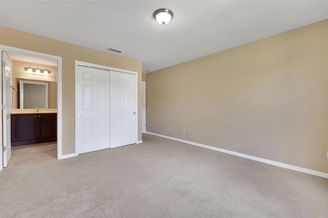 unfurnished bedroom featuring light carpet, baseboards, visible vents, and a closet