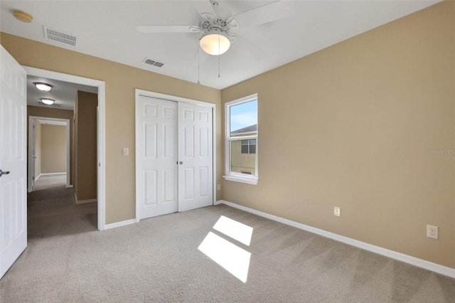 unfurnished bedroom with a closet, carpet flooring, visible vents, and baseboards