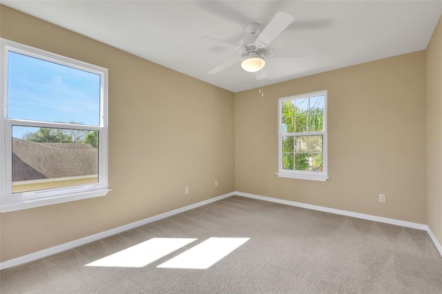 empty room featuring carpet floors, baseboards, and a ceiling fan