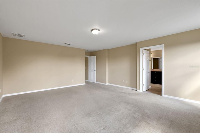 carpeted spare room with visible vents and baseboards