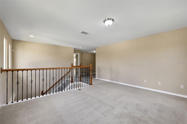 carpeted empty room with visible vents and baseboards