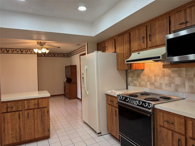 kitchen with brown cabinets, stainless steel microwave, electric range oven, and exhaust hood