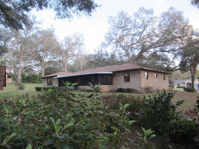 view of home's exterior with brick siding and a lawn