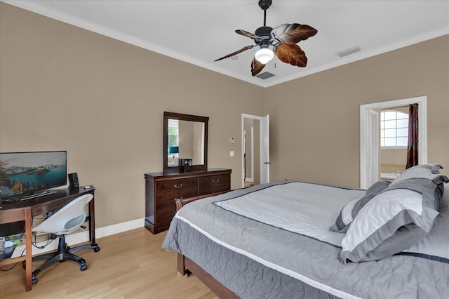 bedroom featuring baseboards, light wood-style floors, visible vents, and crown molding