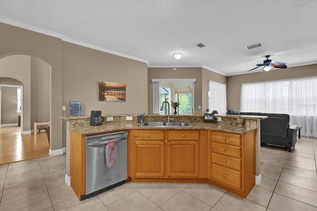 kitchen with arched walkways, light tile patterned flooring, a sink, visible vents, and dishwasher