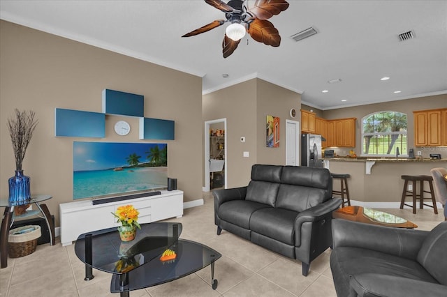 living room with visible vents, crown molding, baseboards, and light tile patterned floors