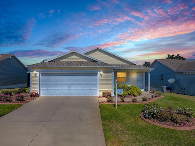 ranch-style house with a garage, cooling unit, a lawn, and concrete driveway