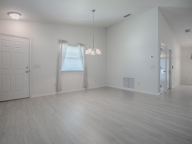 unfurnished dining area featuring a notable chandelier, baseboards, visible vents, and light wood-style floors