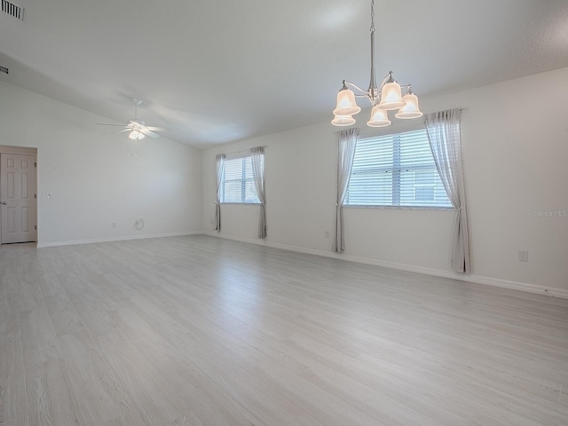 unfurnished room with lofted ceiling, ceiling fan with notable chandelier, visible vents, baseboards, and light wood finished floors