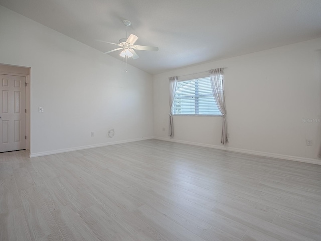 unfurnished room featuring vaulted ceiling, light wood-style flooring, baseboards, and ceiling fan