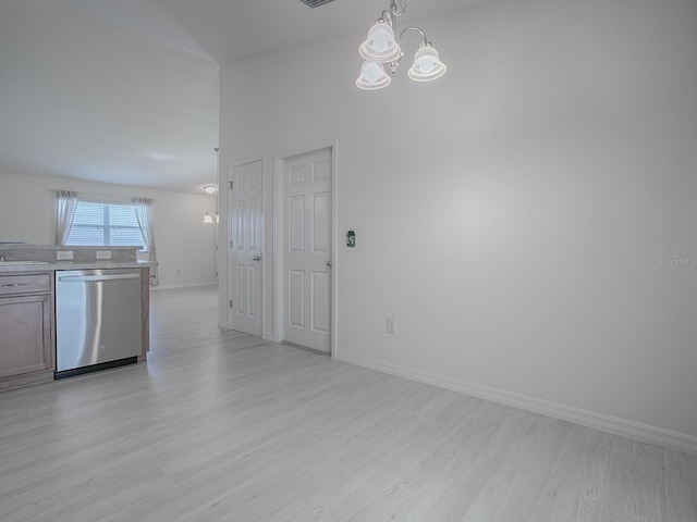 interior space with baseboards, an inviting chandelier, light countertops, light wood-type flooring, and stainless steel dishwasher